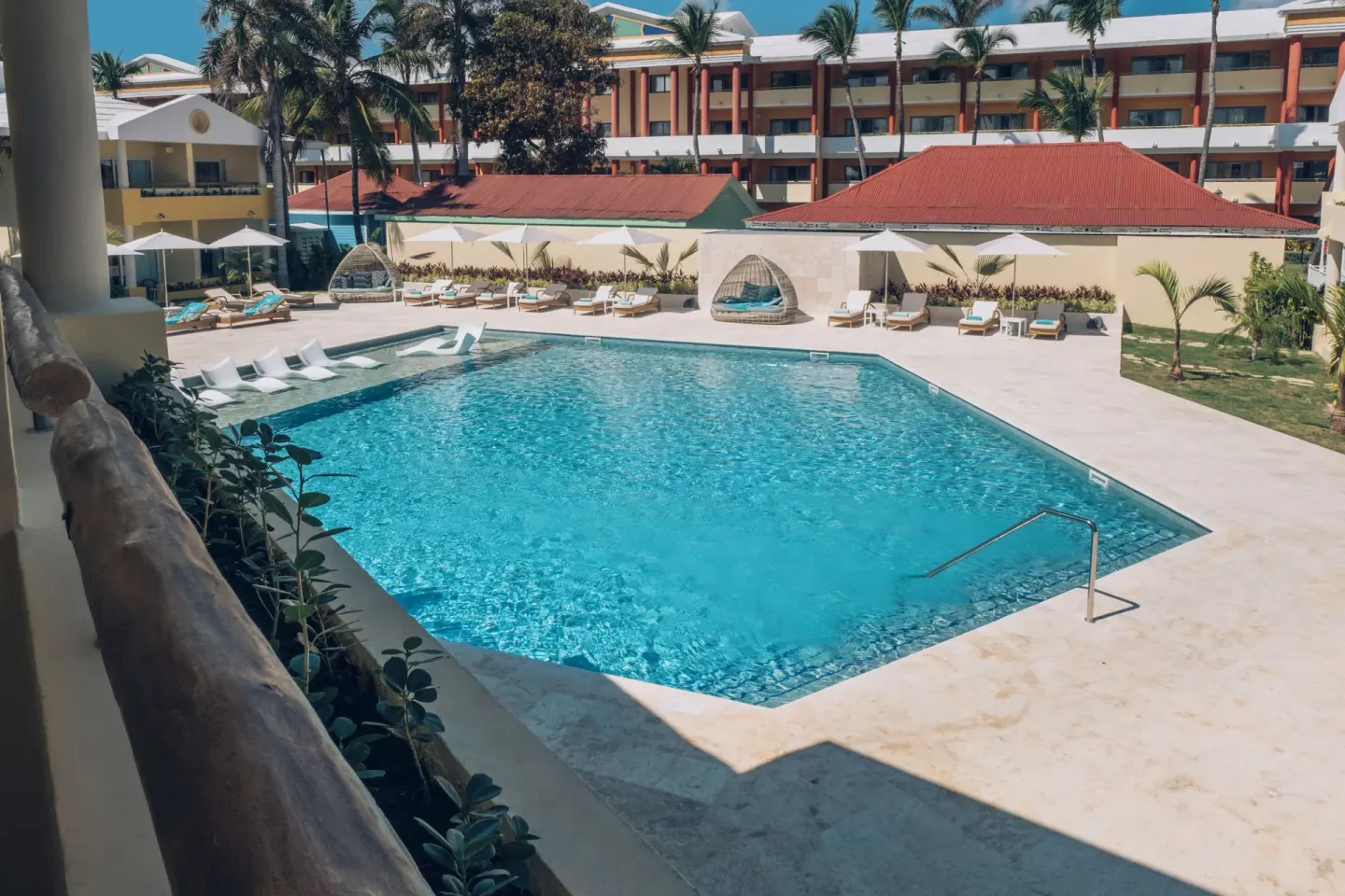 Pool courtyard with loungers and cabana chairs at Iberostar Selection Coral Bávaro.