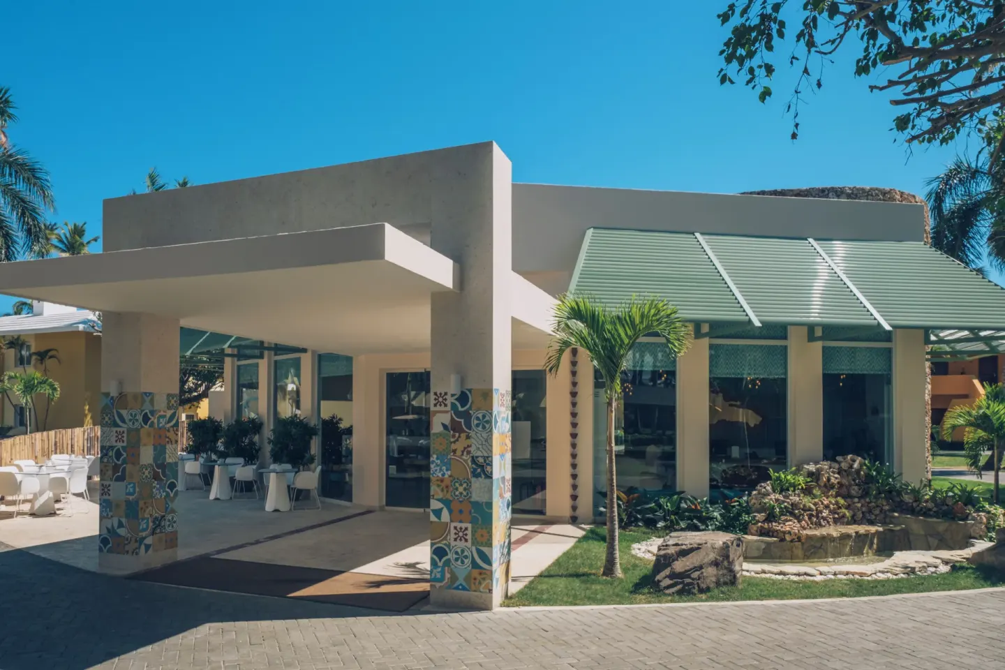 Exterior entrance with patterned columns and palms at Iberostar Selection Coral Bávaro.