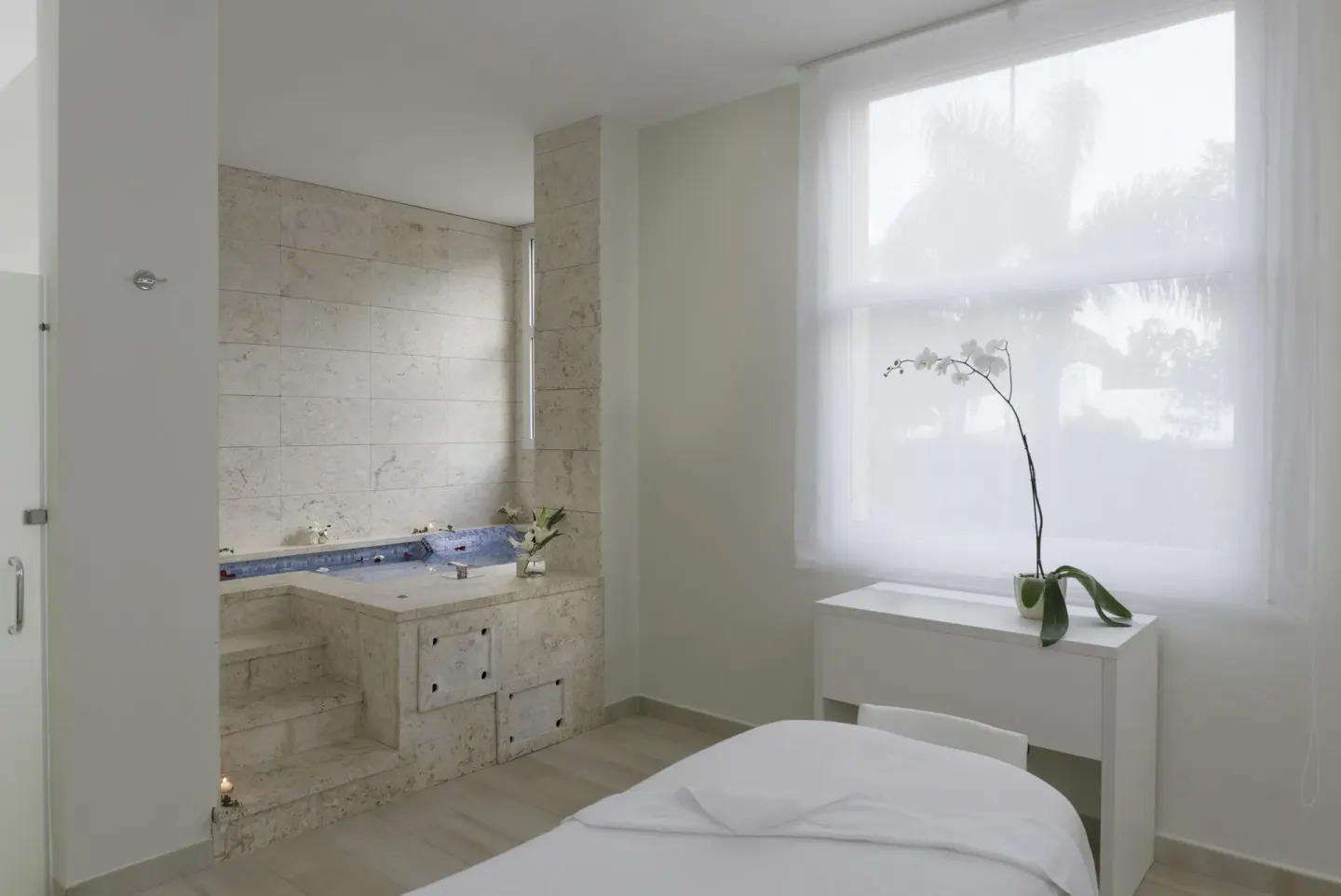 Spa treatment room with massage table and tiled tub area at Iberostar Selection Coral Bávaro.