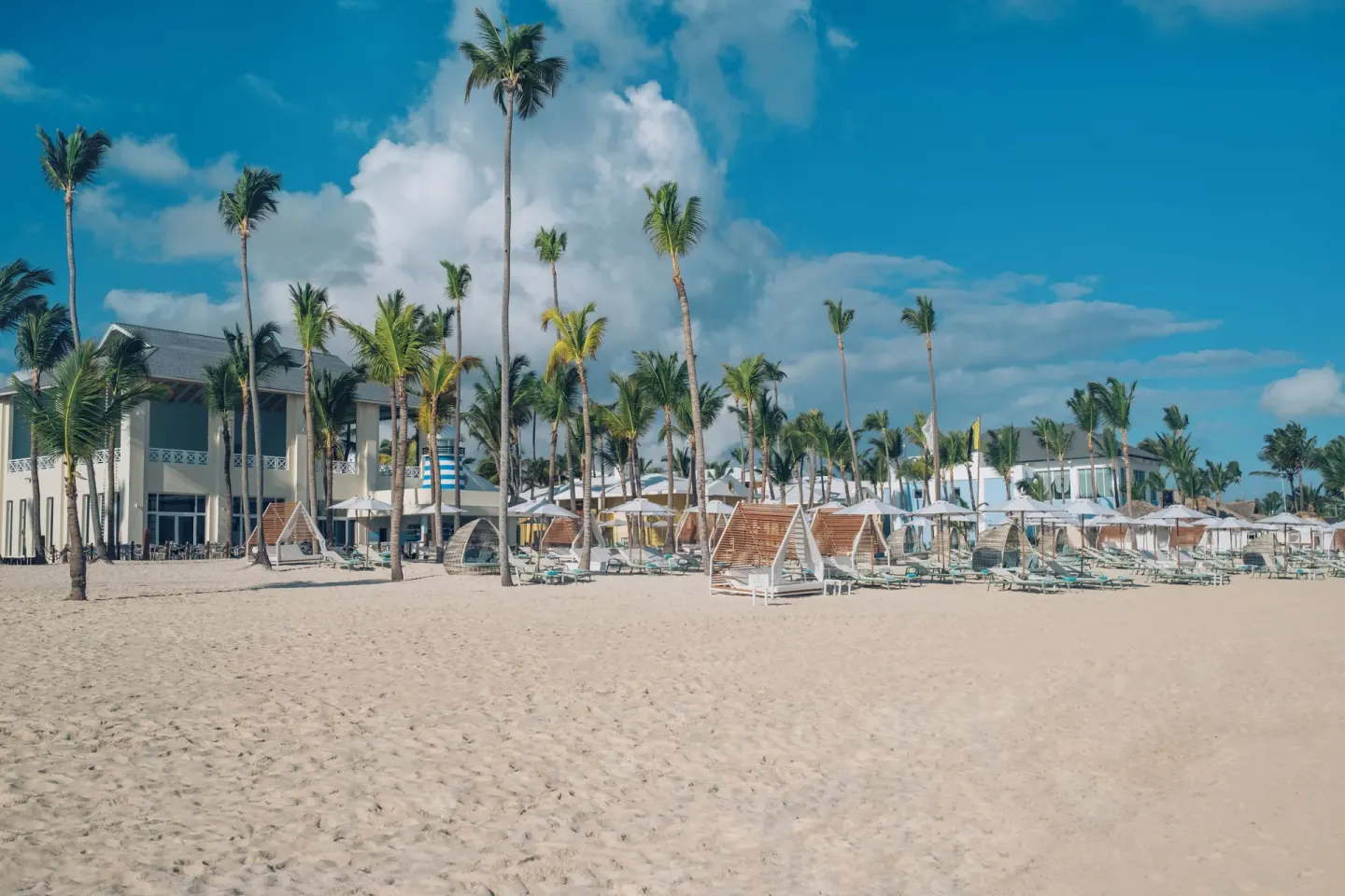 Wide sandy beach with palms, loungers, and resort buildings at Iberostar Selection Coral Bávaro.