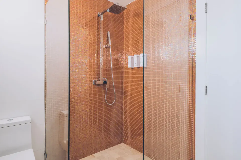 Junior Suite bathroom shower with orange tile at Iberostar Selection Coral Bávaro.