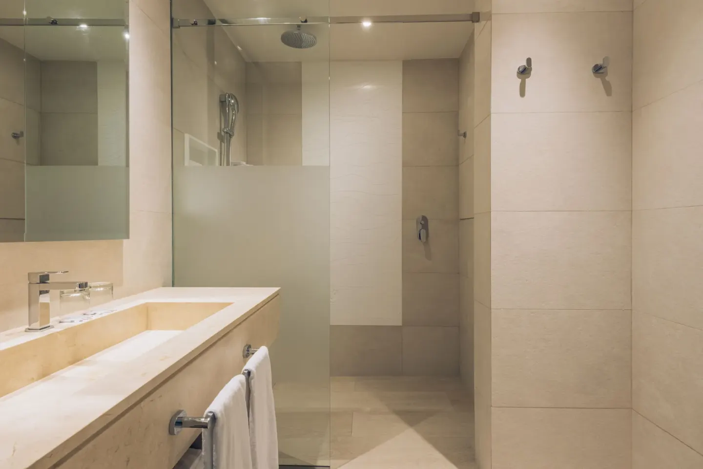 Junior Suite bathroom vanity and glass shower at Iberostar Selection Coral Bávaro.
