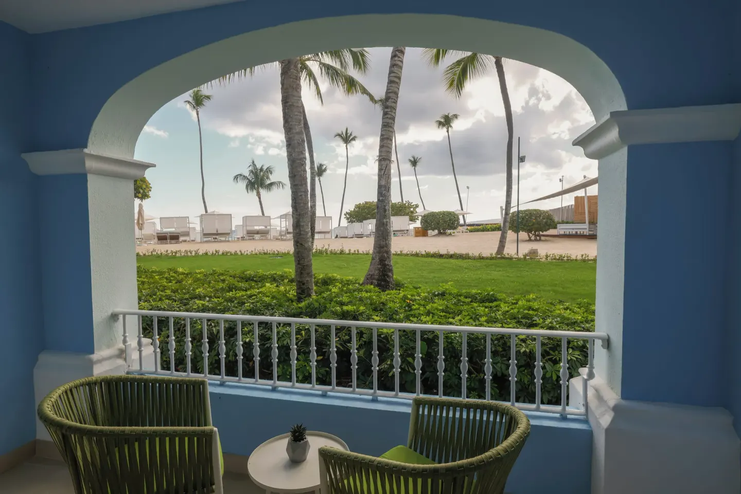 Blue balcony with chairs and palm garden view at Iberostar Selection Hacienda Dominicus.