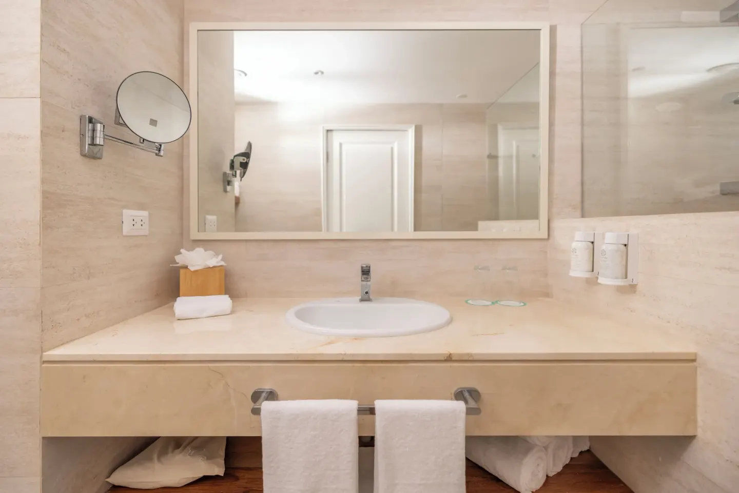 Bathroom vanity with sink, mirror, towels, and shower glass at Iberostar Selection Hacienda Dominicus.