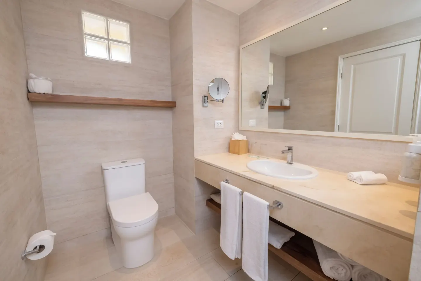 Bathroom with vanity, toilet, and large mirror at Iberostar Selection Hacienda Dominicus.
