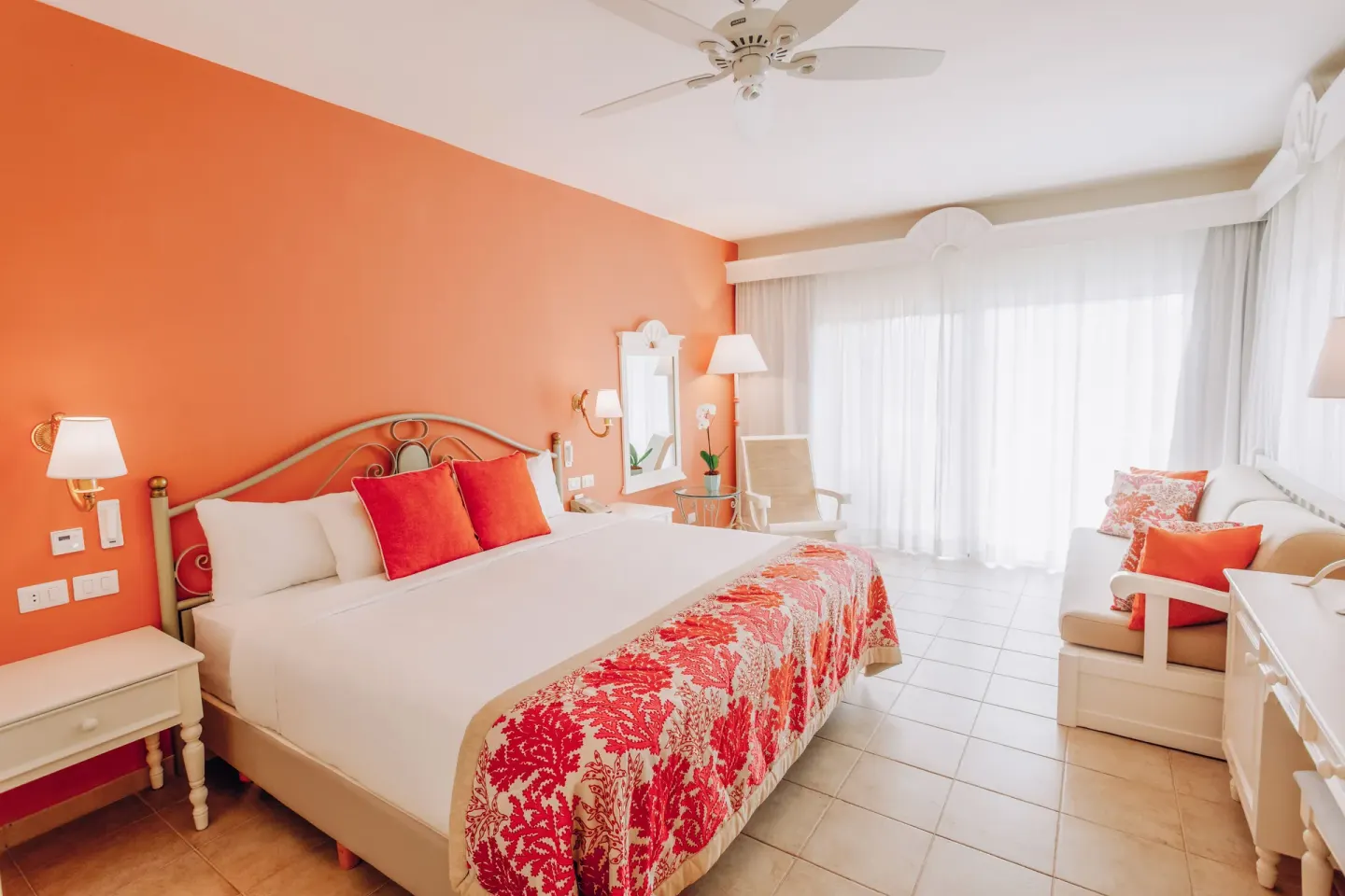 King bed guest room with orange accent wall at Iberostar Selection Hacienda Dominicus.