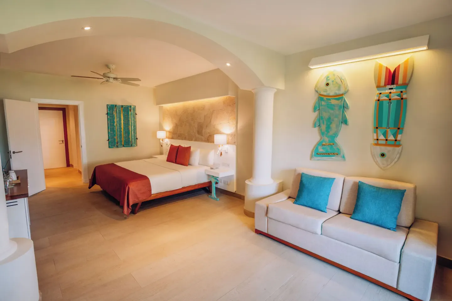 Guest room with king bed, sofa and wall art at Iberostar Selection Hacienda Dominicus.