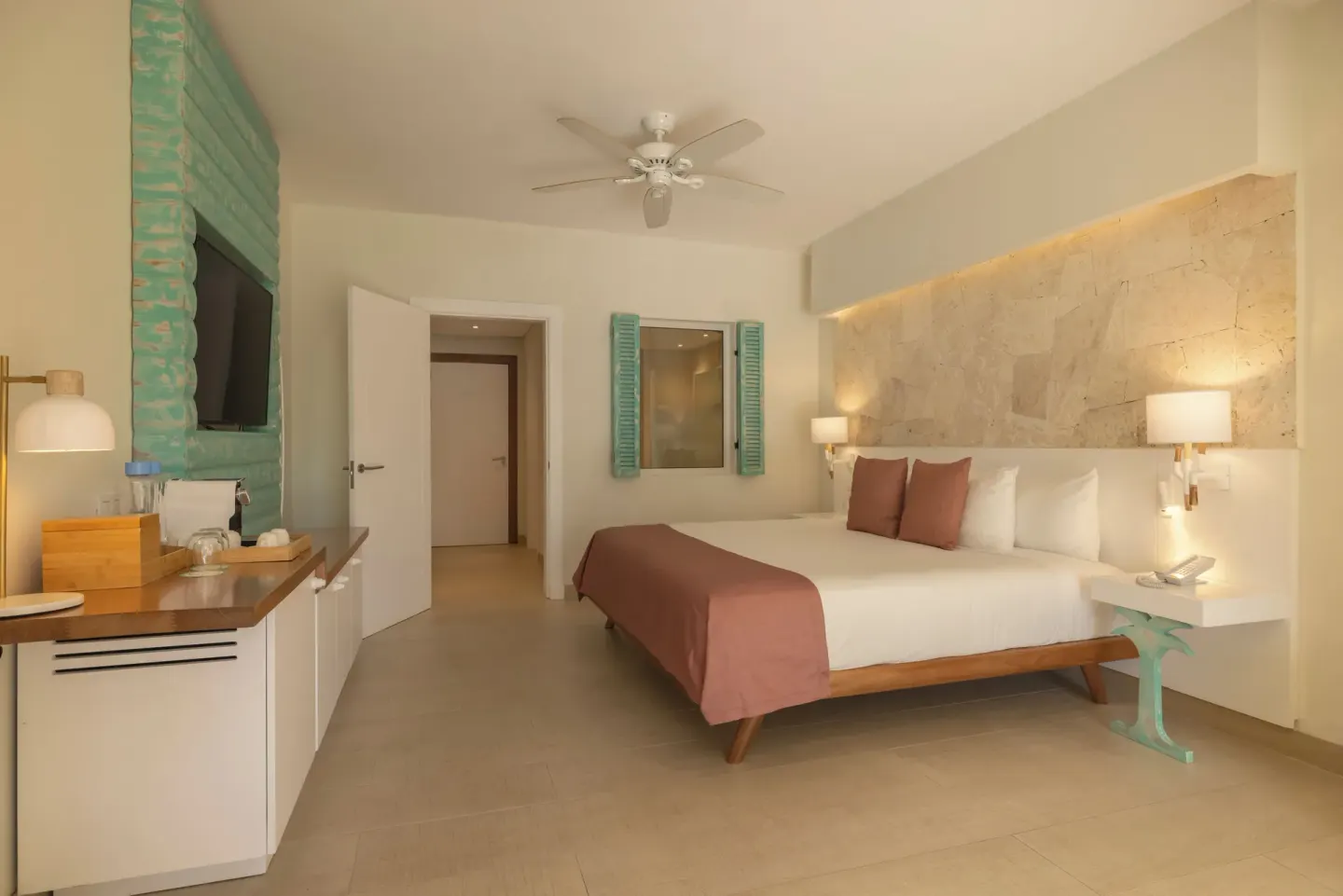 King bed guest room with stone headboard wall at Iberostar Selection Hacienda Dominicus.