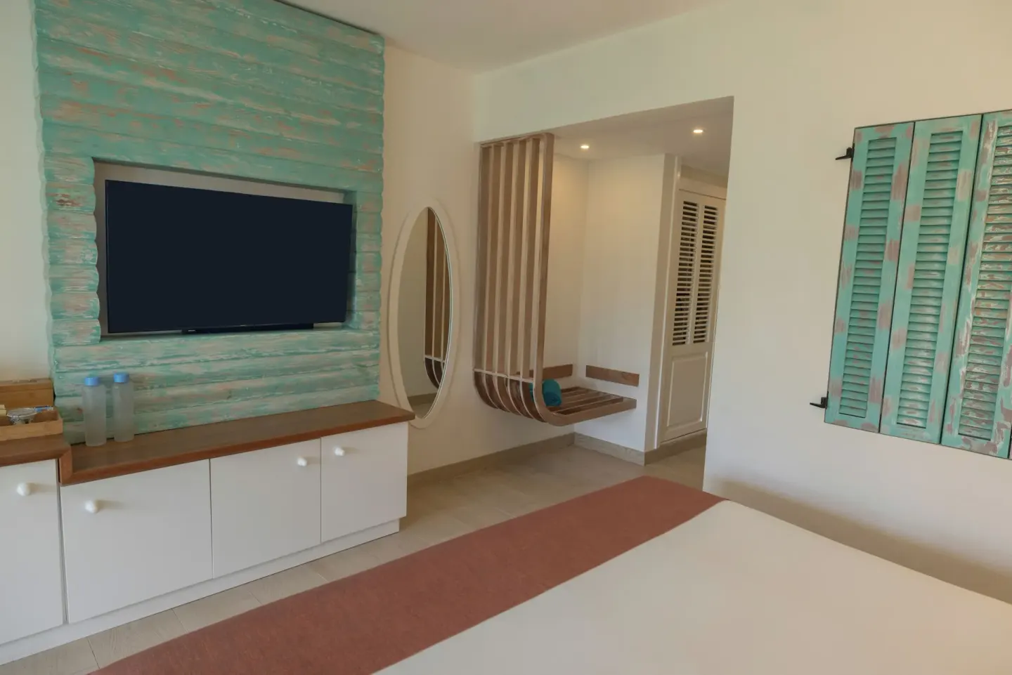 Guest room TV wall, mirror and bed at Iberostar Selection Hacienda Dominicus.