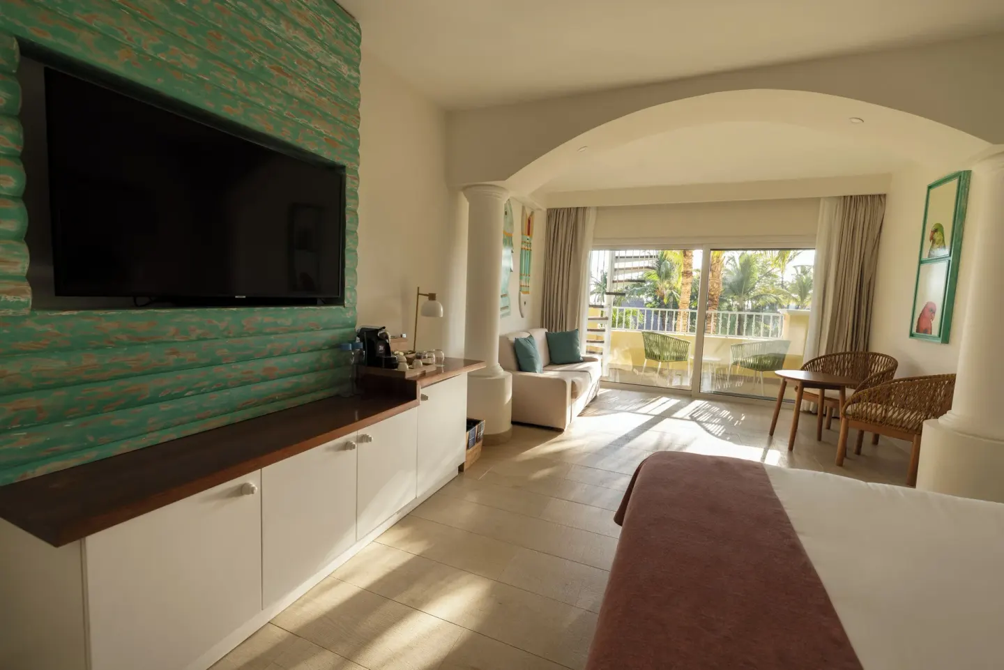 Guest room with bed, TV wall and balcony at Iberostar Selection Hacienda Dominicus.