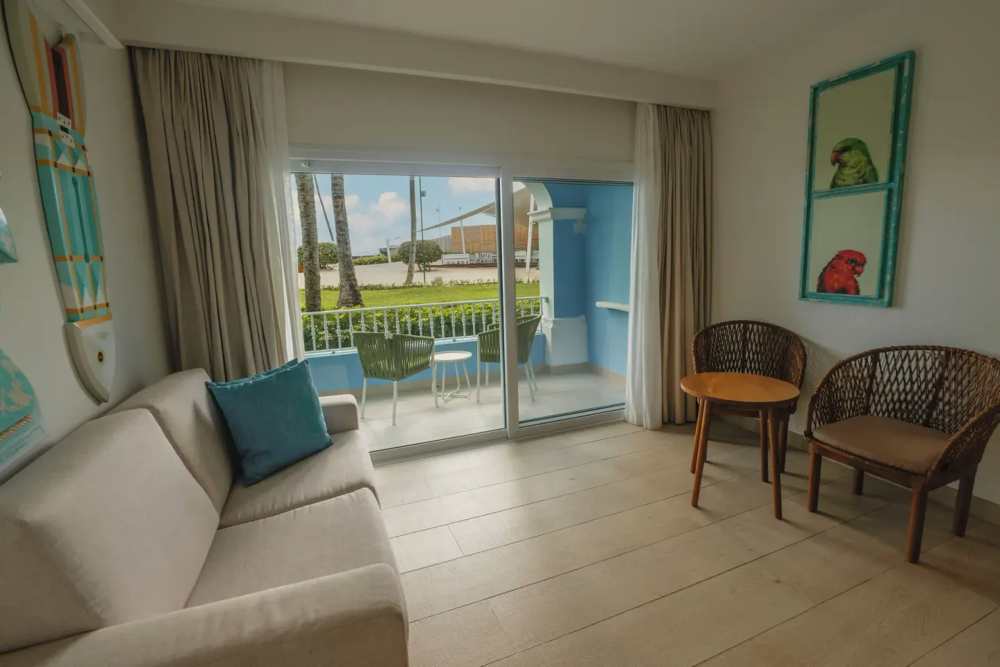 Sitting area with sofa, chairs and balcony in a guest room at Iberostar Selection Hacienda Dominicus.