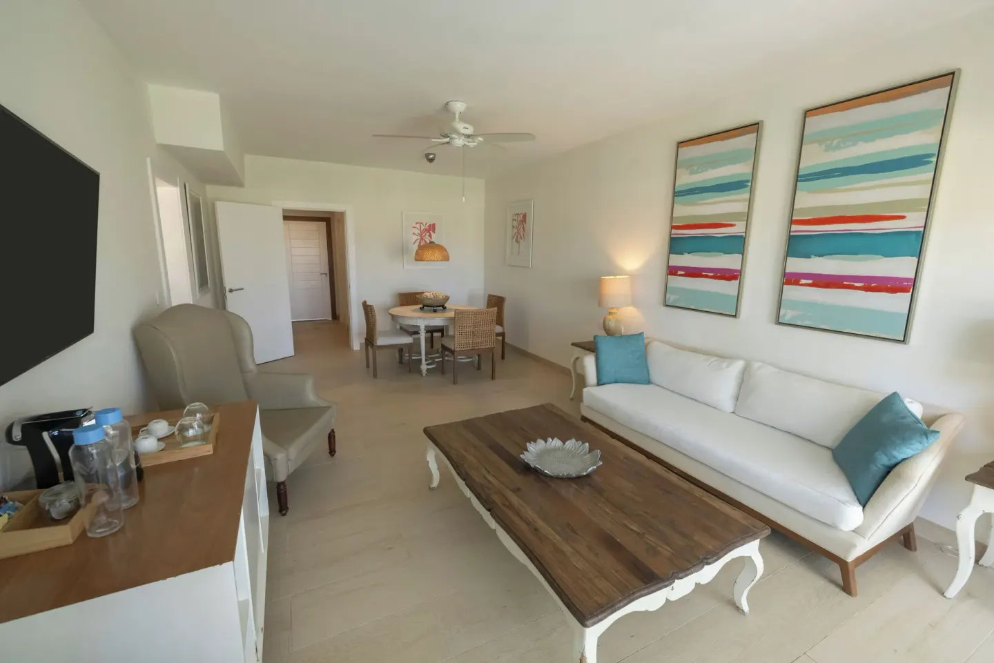 Suite living area with sofa, dining table and TV at Iberostar Selection Hacienda Dominicus.