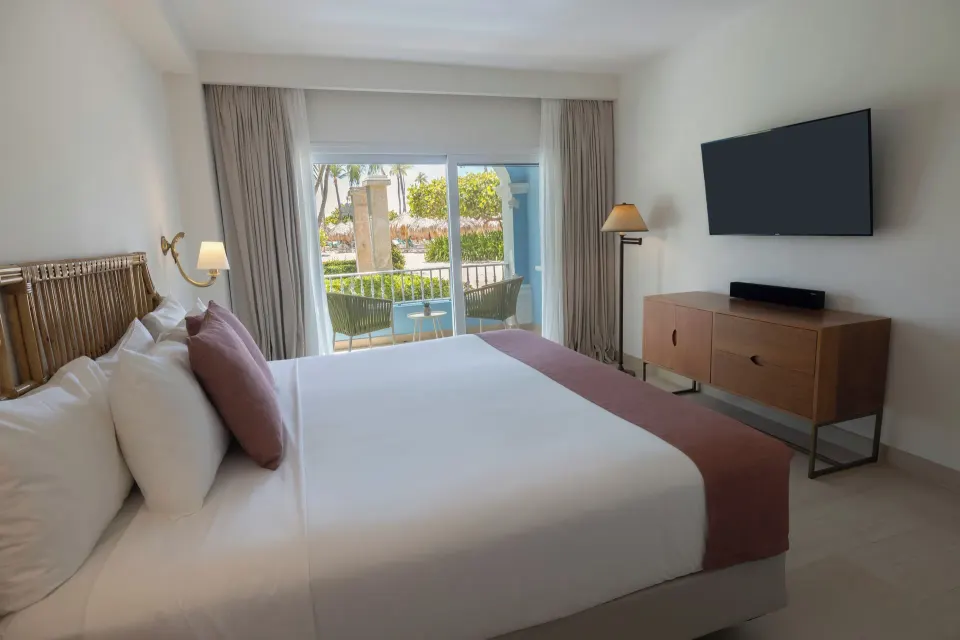 Suite bedroom with king bed and balcony at Iberostar Selection Hacienda Dominicus.