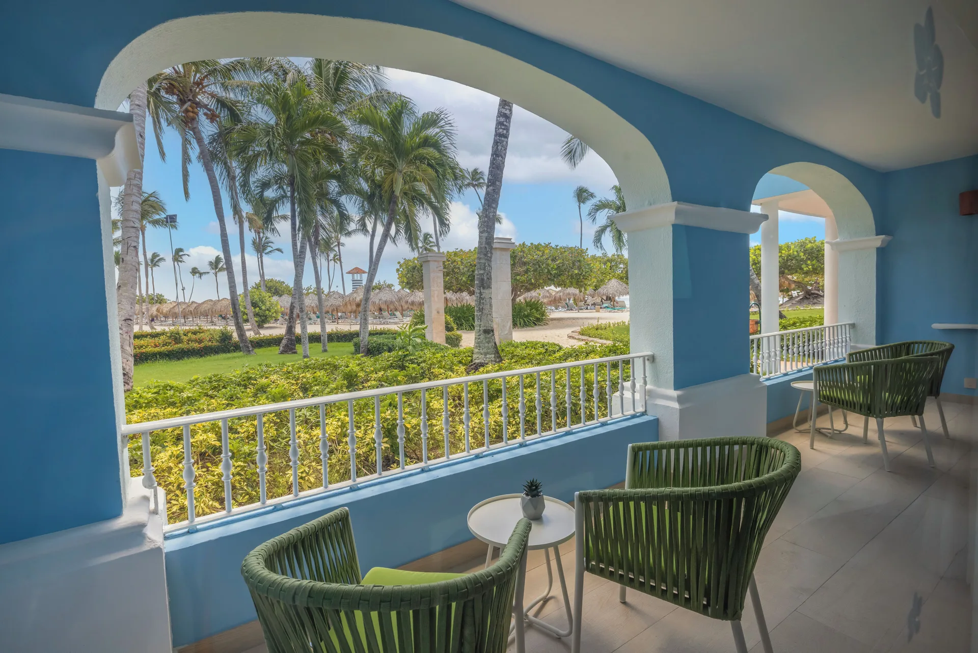 Suite terrace with green chairs and palm views at Iberostar Selection Hacienda Dominicus.