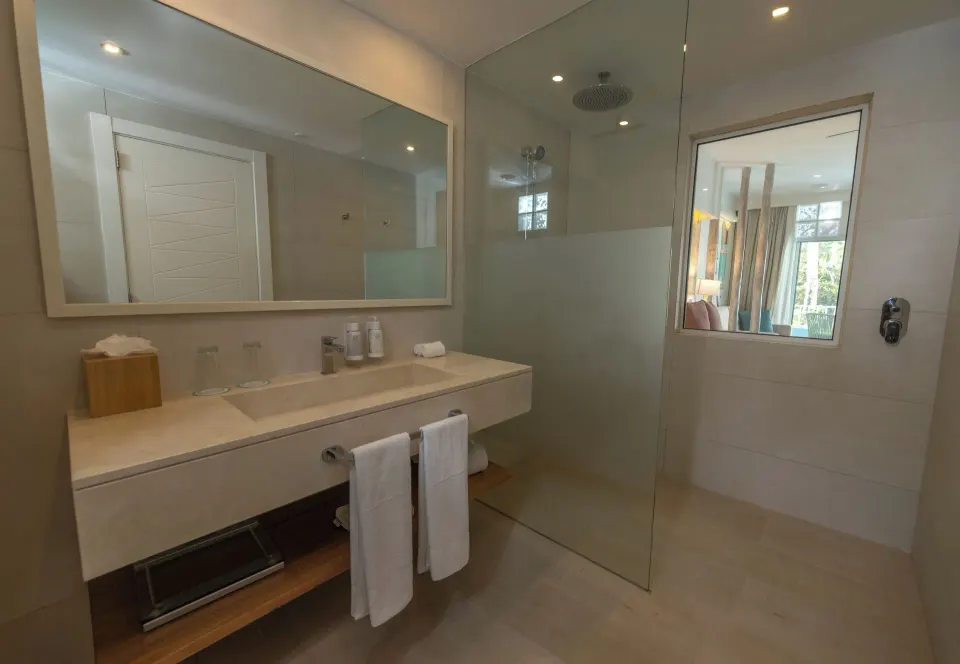 Superior room bathroom with double vanity and glass shower at Iberostar Selection Hacienda Dominicus.