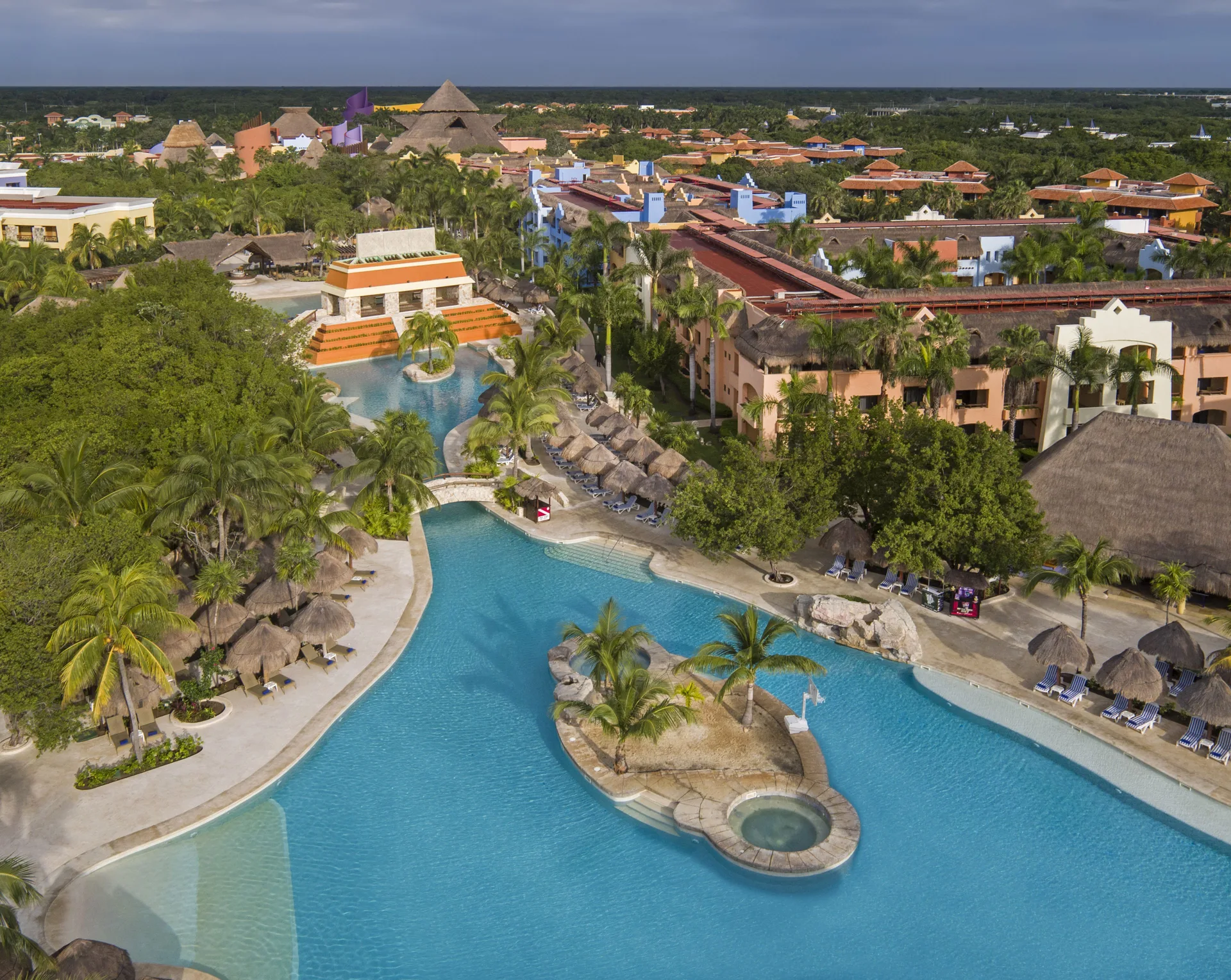 Large pool with palms, loungers, and resort buildings at Iberostar Selection Paraíso Lindo.