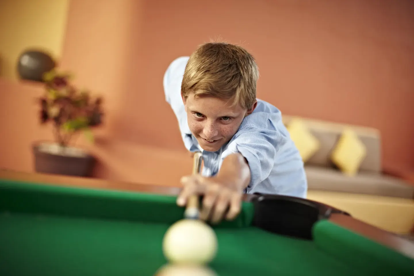 A child lines up a billiards shot at Iberostar Selection Paraíso Lindo.
