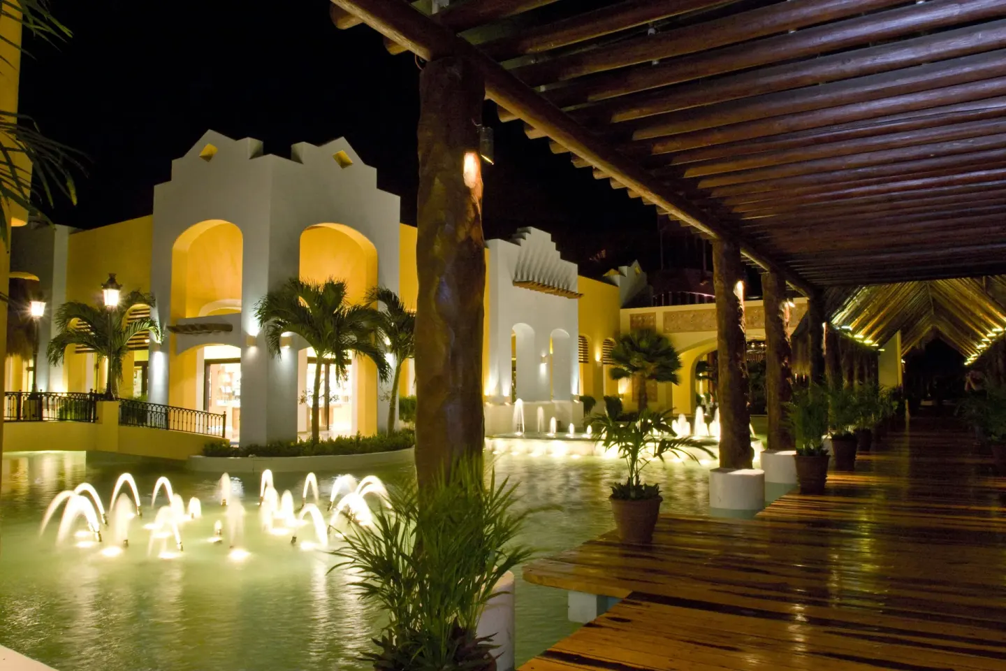Nighttime resort walkway with fountains at Iberostar Selection Paraíso Lindo.