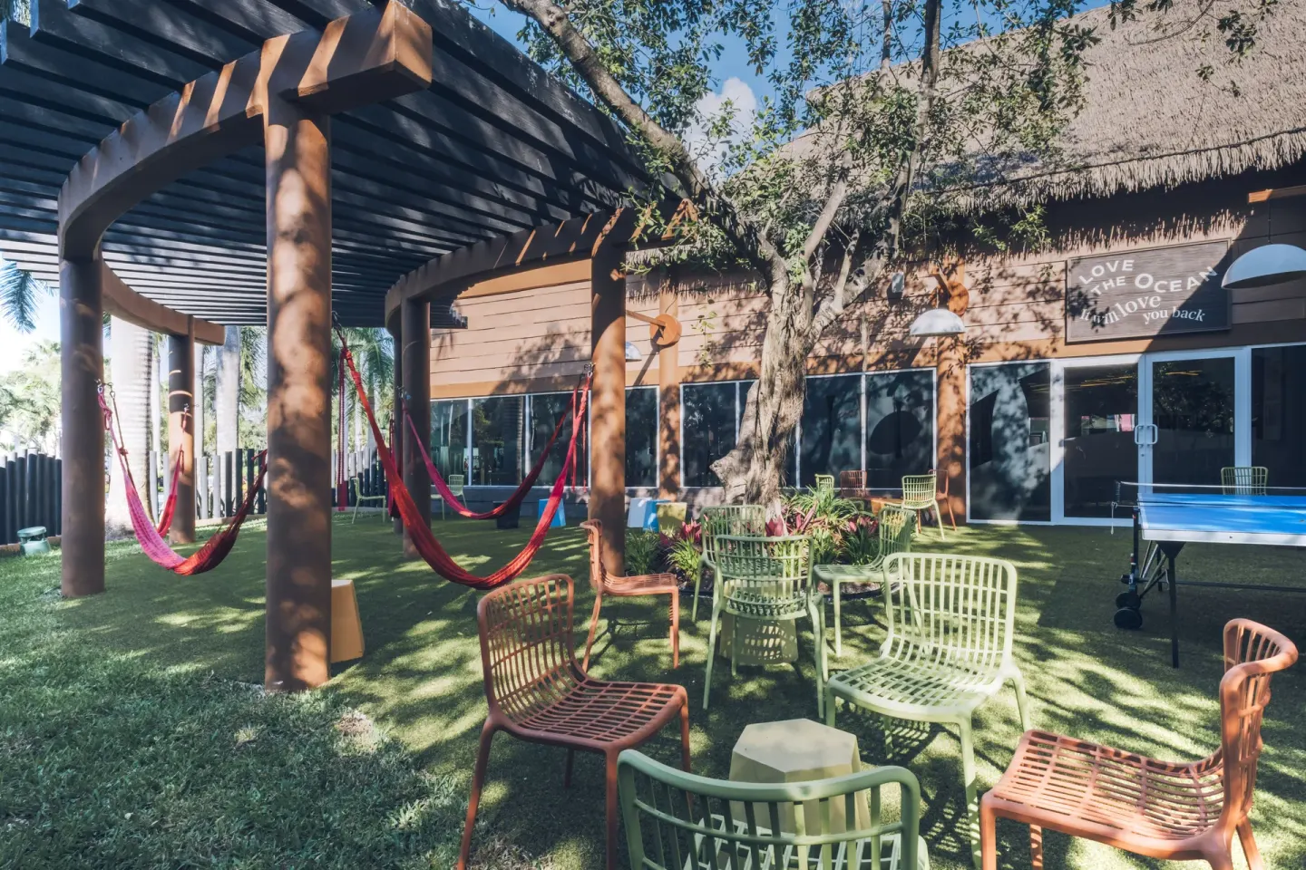 Outdoor seating, hammocks, and a ping-pong table at Iberostar Selection Paraíso Lindo.
