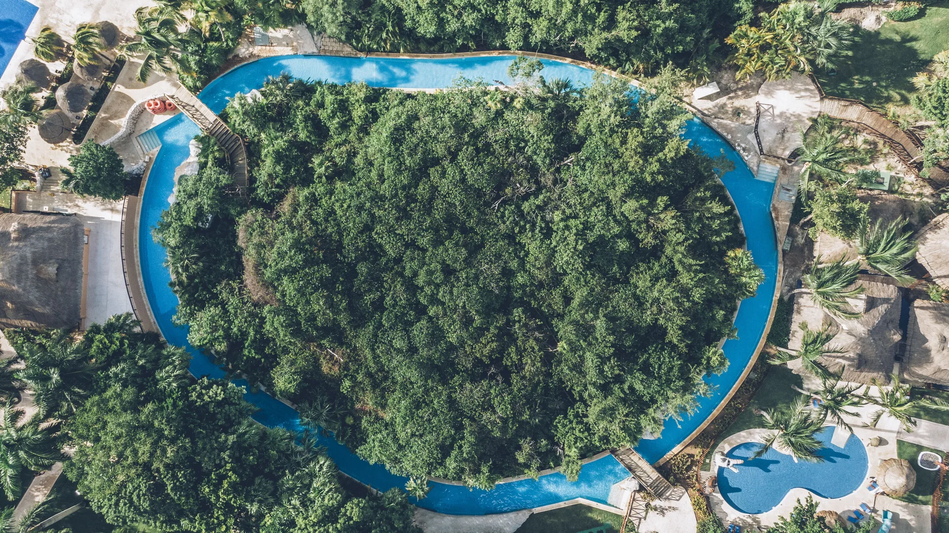 Overhead view of a blue waterway around dense greenery at Iberostar Selection Paraíso Lindo.