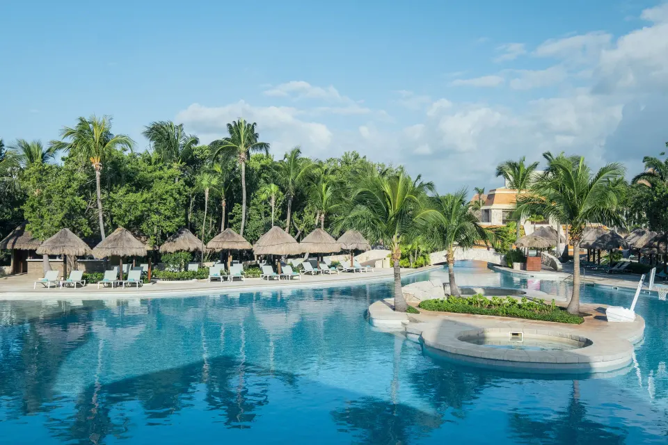 Swimming pool island with palms and surrounding loungers at Iberostar Selection Paraíso Lindo.