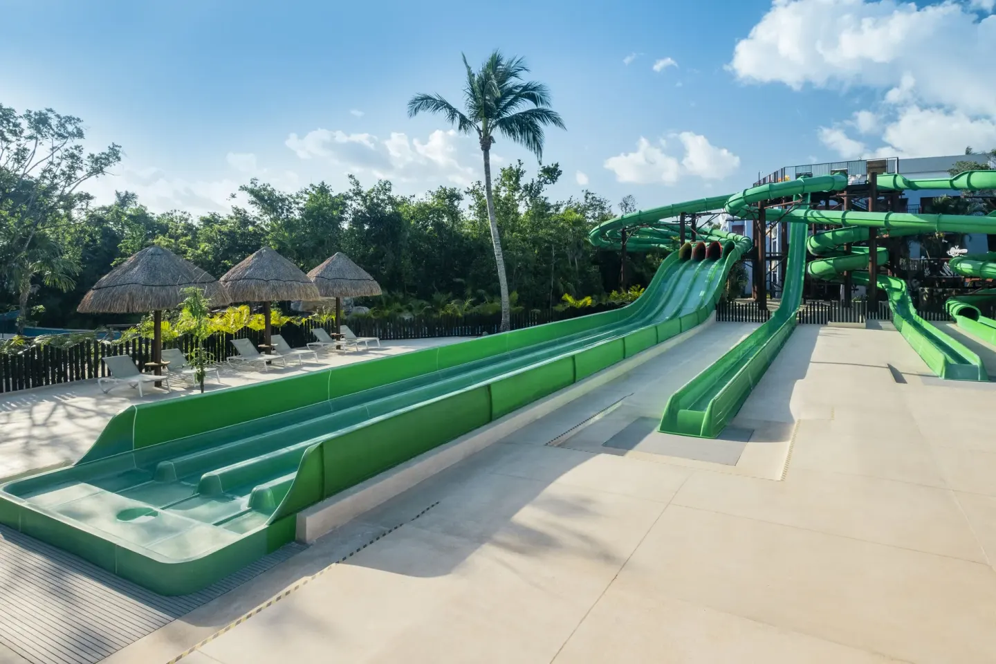 Green water slide runouts and shaded loungers at Iberostar Selection Paraíso Lindo.