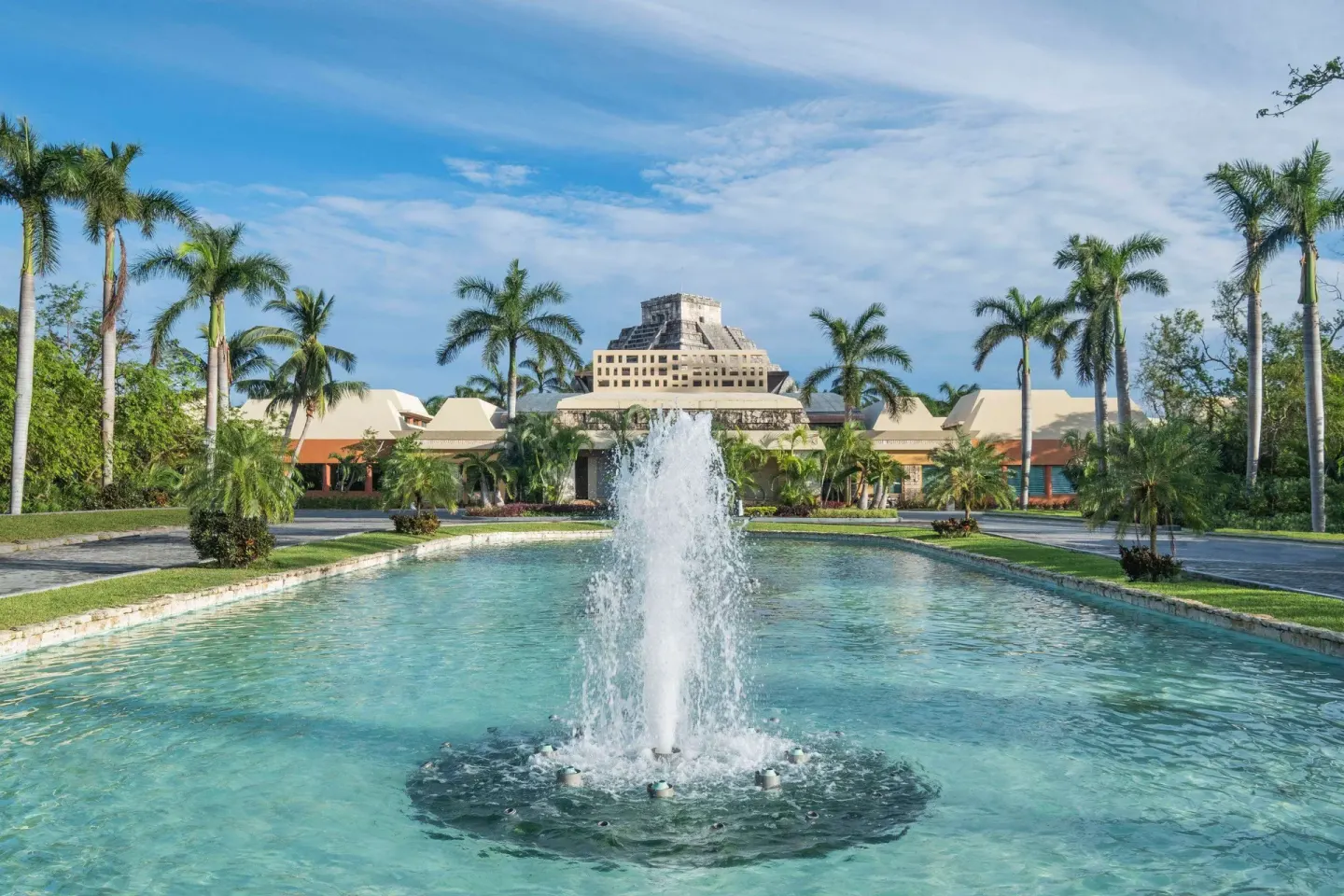 Fountain and palm-lined approach at Iberostar Selection Paraíso Maya Suites.