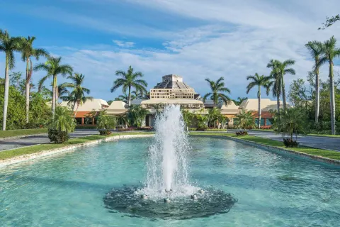 Fountain and palm-lined approach at Iberostar Selection Paraíso Maya Suites.