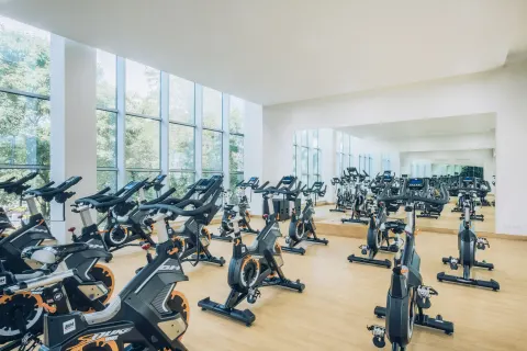 Indoor cycling studio with rows of spin bikes at Iberostar Selection Paraíso Maya Suites.