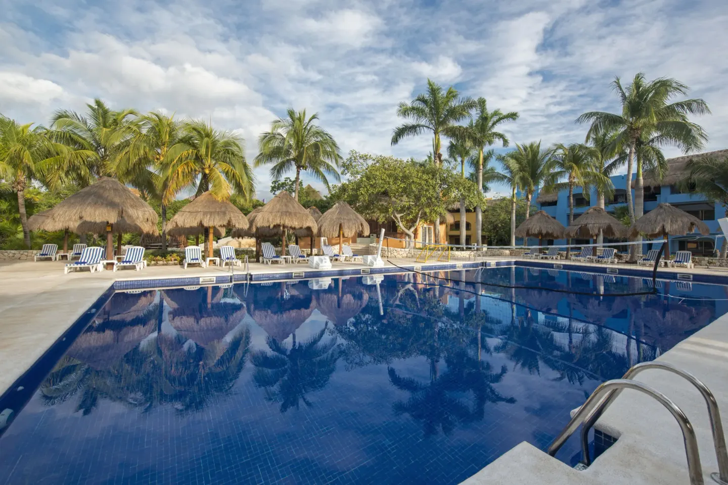 Outdoor pool with palapas and lounge chairs at Iberostar Selection Paraíso Maya Suites.