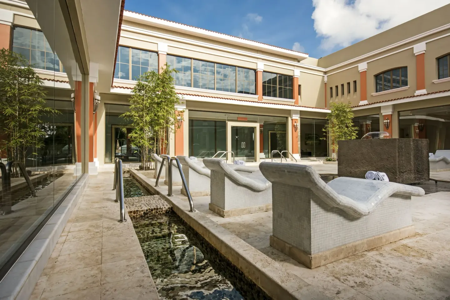 Outdoor spa hydrotherapy area with tiled loungers at Iberostar Selection Paraíso Maya Suites.