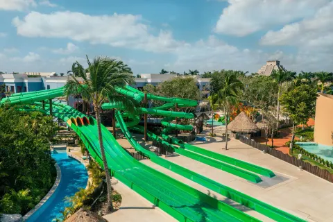 Green water slides and lazy river area at Iberostar Selection Paraíso Maya Suites.