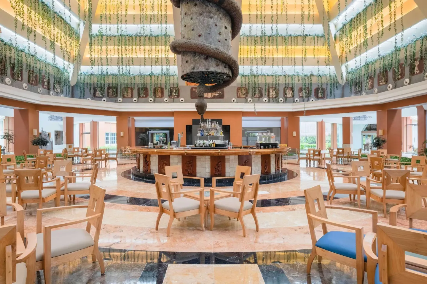 Large circular lobby bar with dining tables at Iberostar Selection Paraíso Maya Suites.