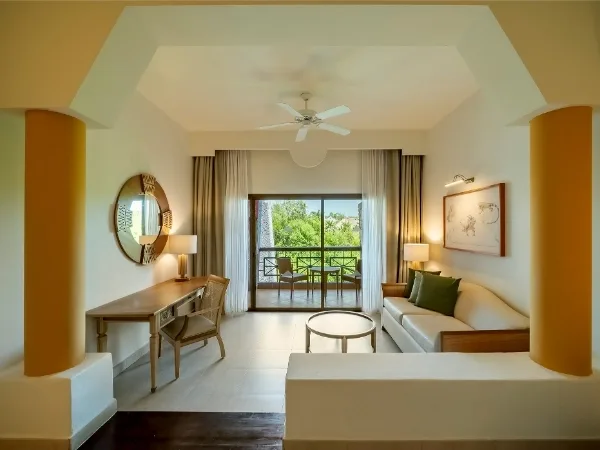 Junior Suite Near Pool living area with sofa and balcony at Iberostar Selection Paraíso Maya Suites.