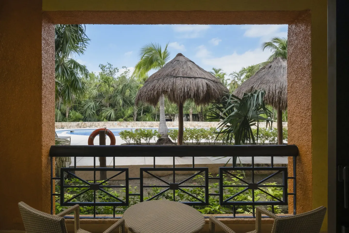 Junior Suite balcony overlooking pool palapas at Iberostar Selection Paraíso Maya Suites.