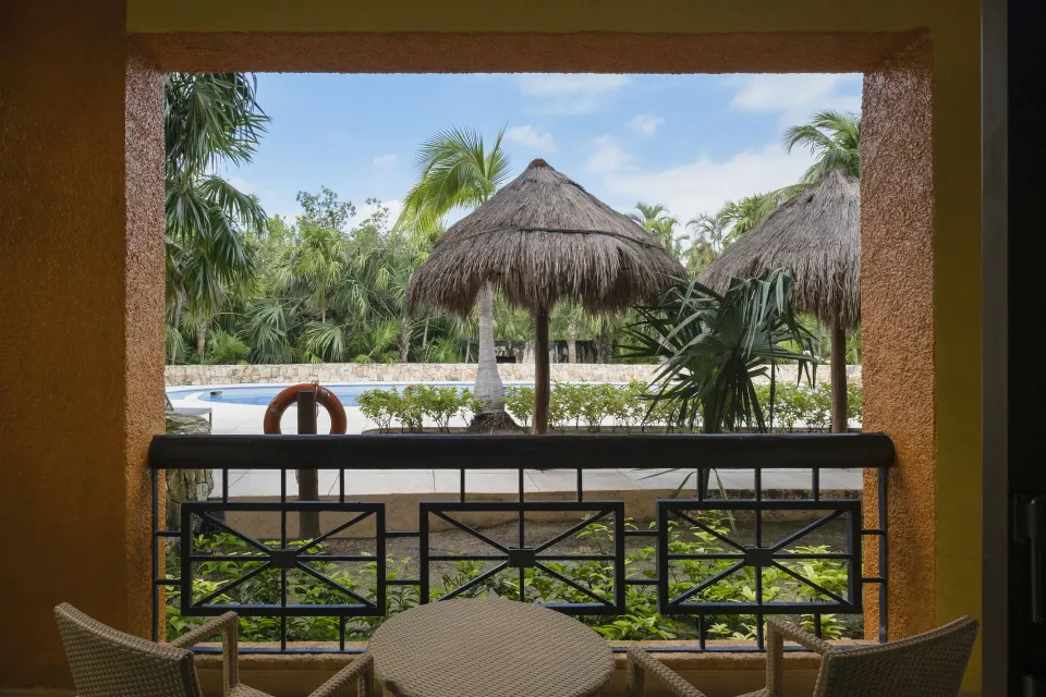 Junior Suite balcony overlooking pool palapas at Iberostar Selection Paraíso Maya Suites.