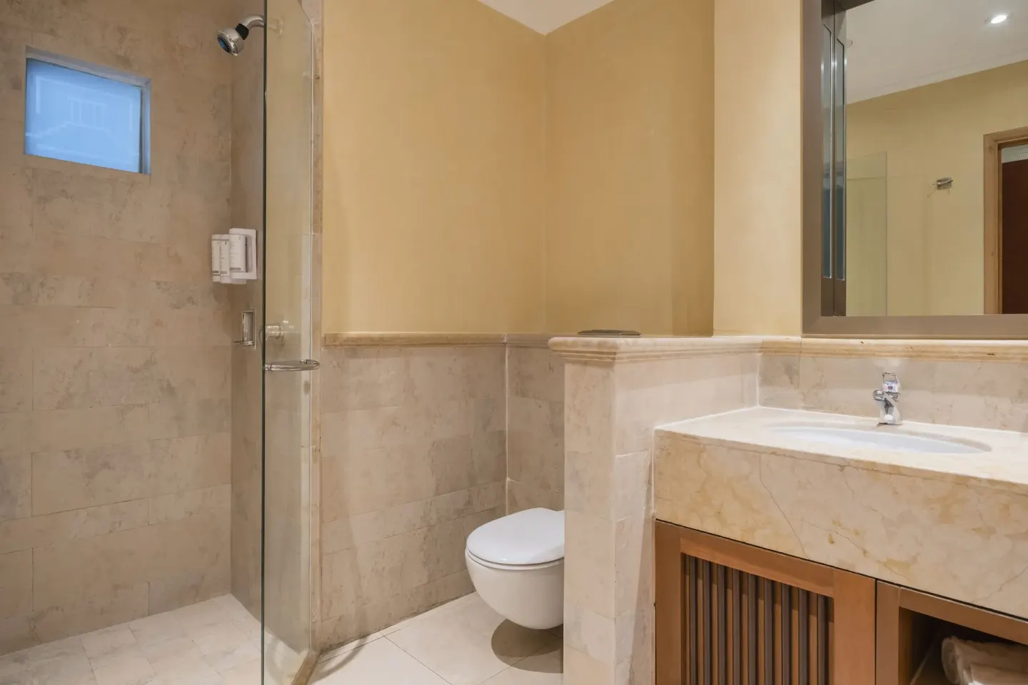 Junior Suite bathroom with shower, toilet, and vanity at Iberostar Selection Paraíso Maya Suites.