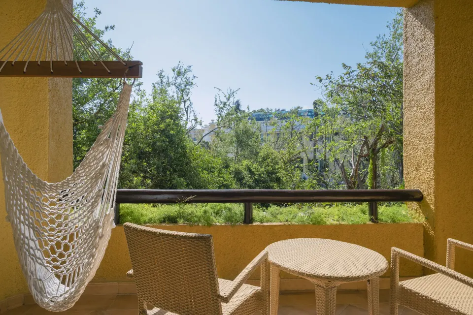 Junior Suite tropical-view balcony with hammock at Iberostar Selection Paraíso Maya Suites.