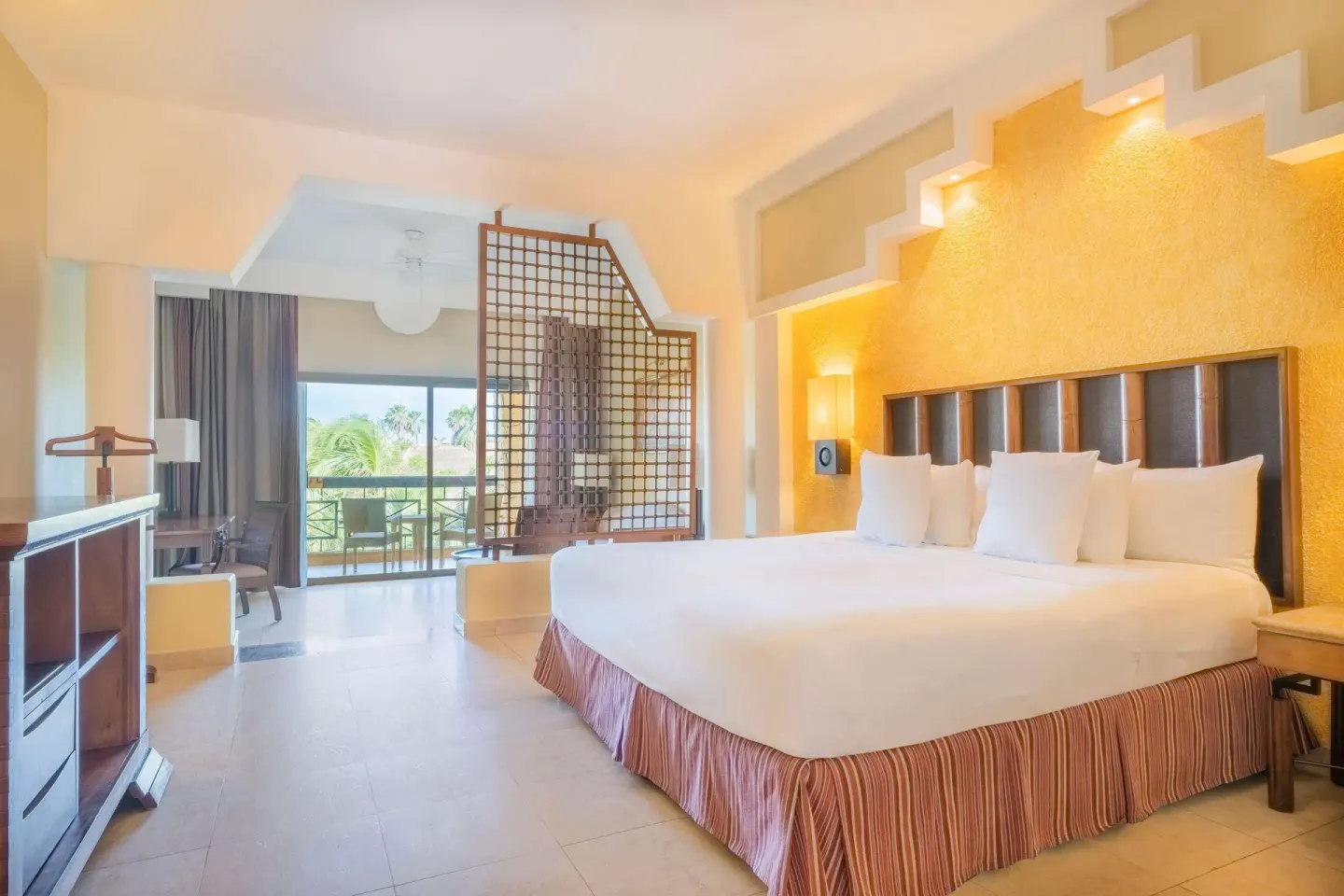 Junior Suite king bed with balcony beyond at Iberostar Selection Paraíso Maya Suites.