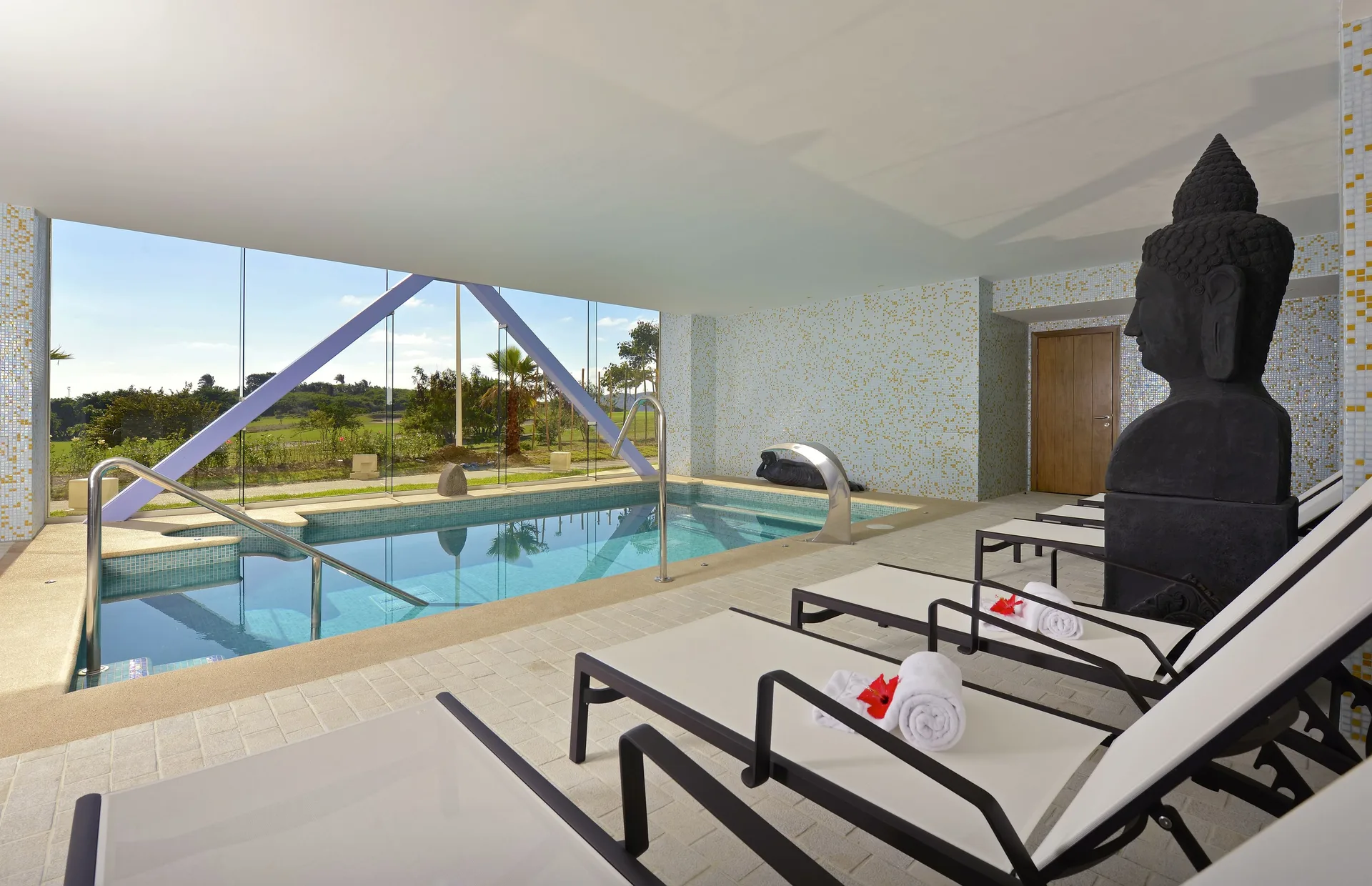 Spa hydrotherapy pool with loungers and Buddha sculpture at Iberostar Selection Playa Mita.