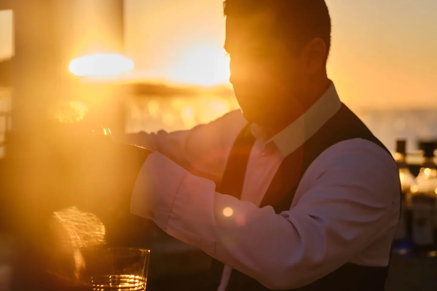 Bartender preparing a drink in warm sunset light at Iberostar Selection Playa Mita.