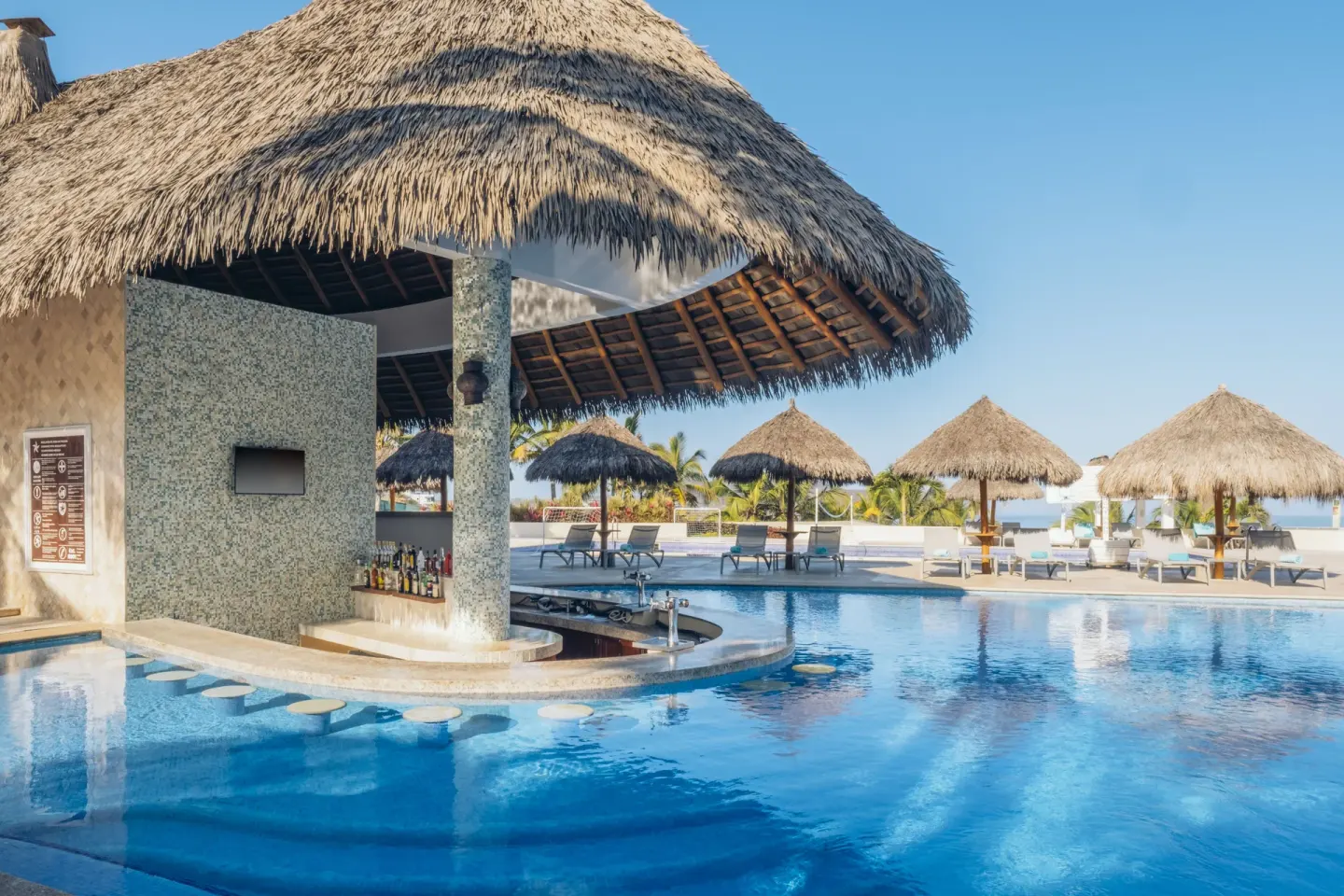 Swim-up pool bar under a thatched roof at Iberostar Selection Playa Mita.