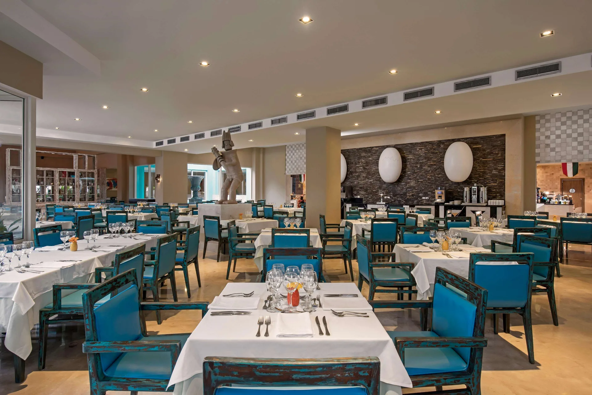 Restaurant dining room with turquoise chairs and white tablecloths at Iberostar Selection Playa Mita.