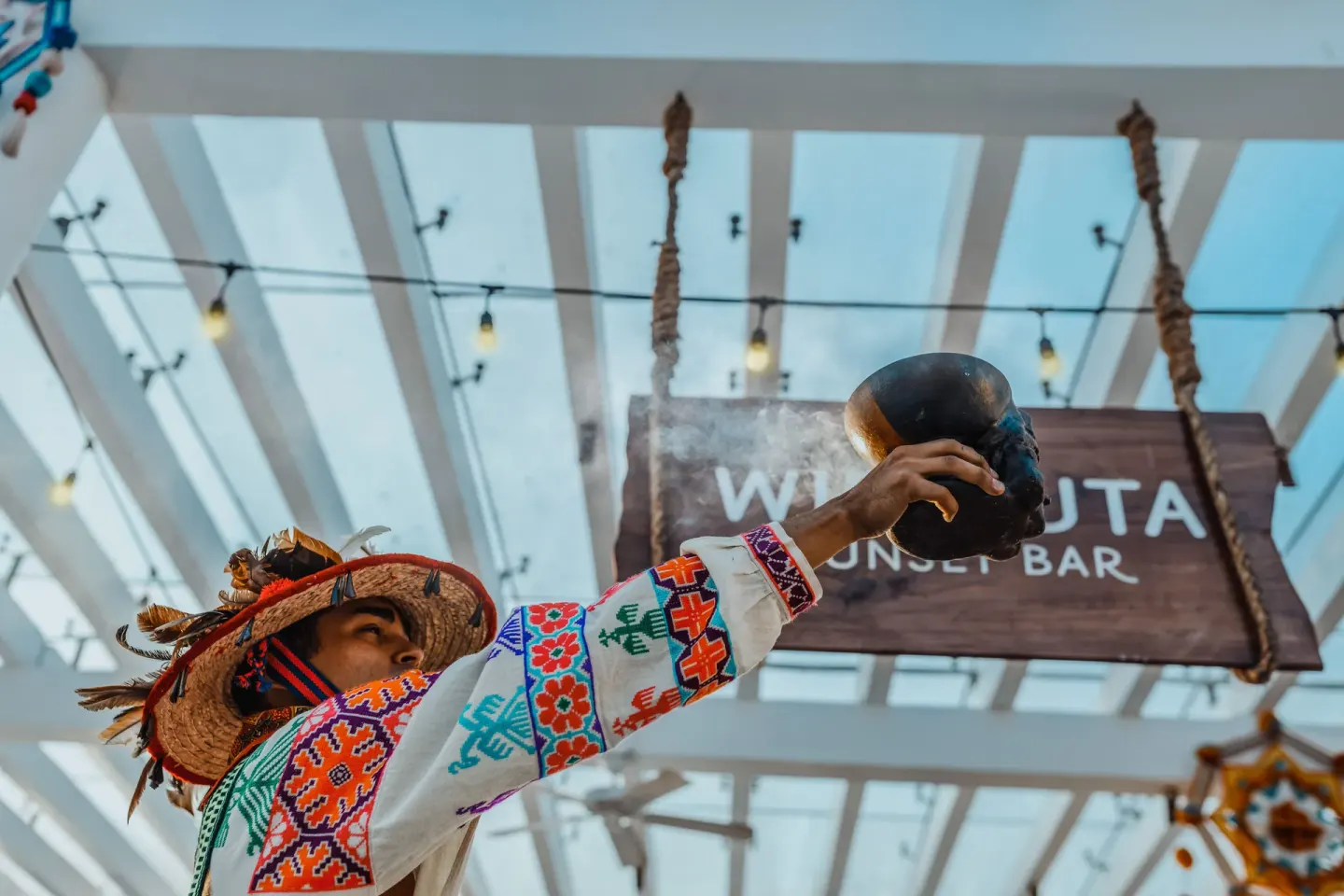 Performer in traditional dress beneath the Wirikuta Sunset Bar sign at Iberostar Selection Playa Mita.