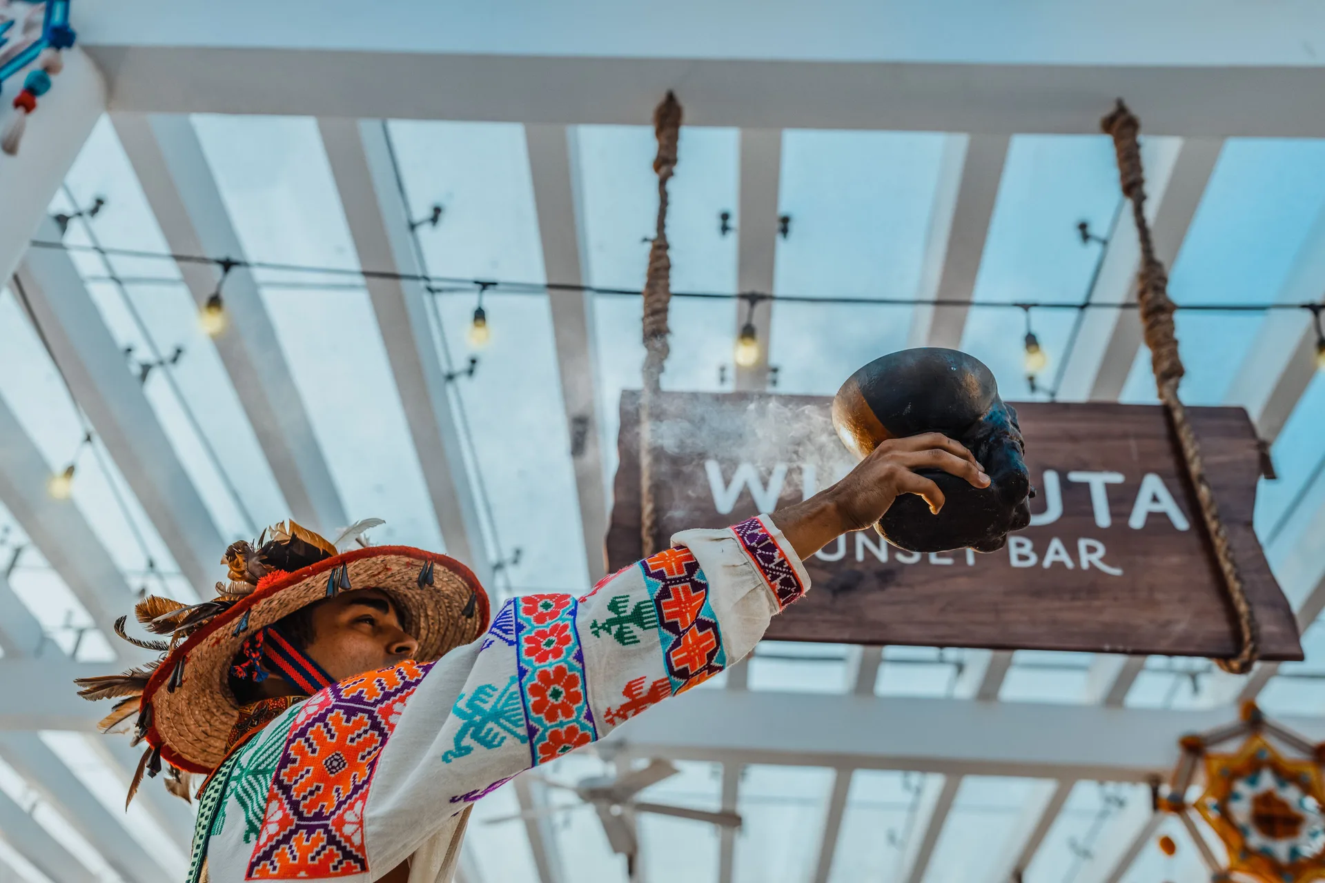 Performer in traditional dress beneath the Wirikuta Sunset Bar sign at Iberostar Selection Playa Mita.