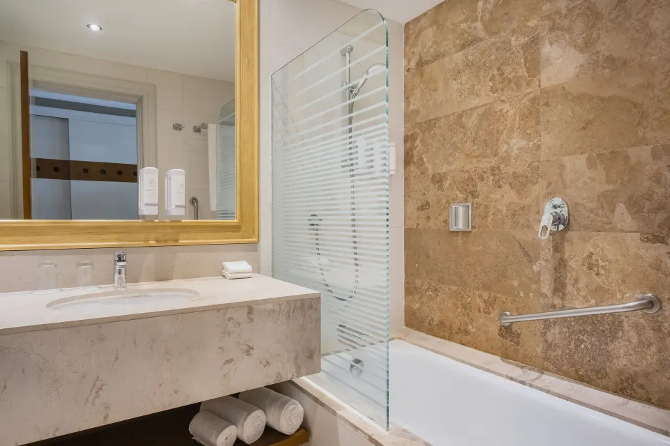 Junior suite bathroom with vanity, tub, and shower at Iberostar Selection Playa Mita.