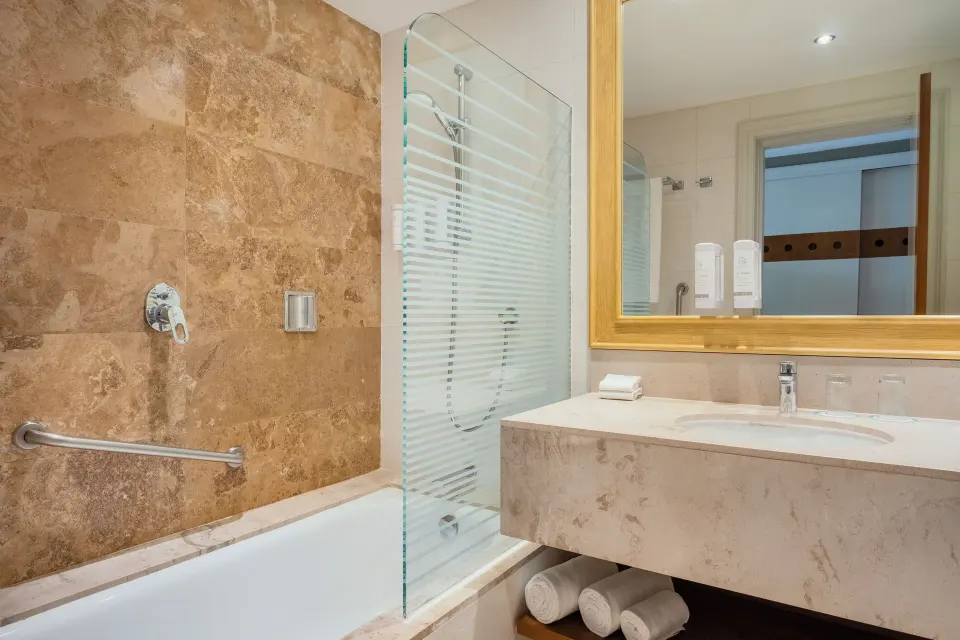 Premium Room bathroom with tub, shower screen, and vanity at Iberostar Selection Playa Mita.