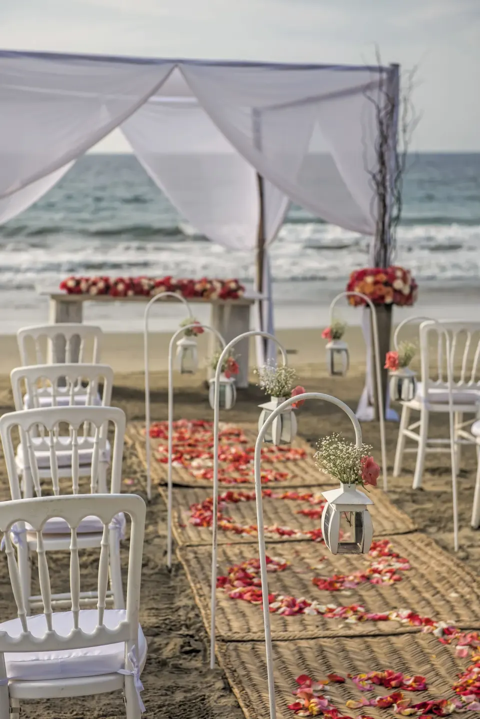 Beach wedding aisle with white chairs and canopy at Iberostar Selection Playa Mita.