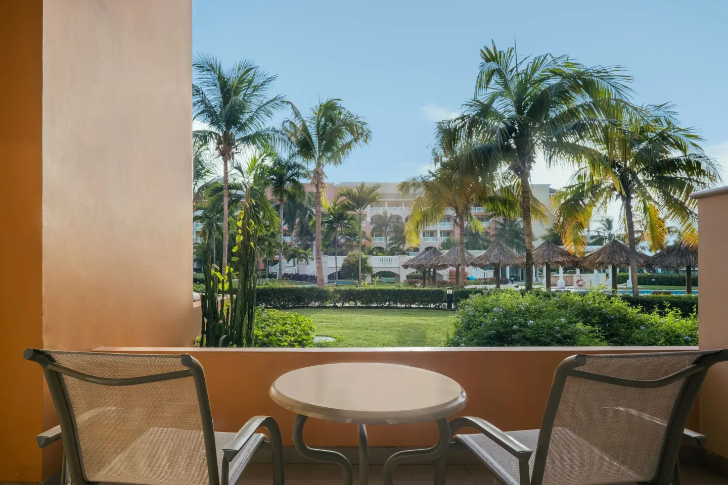 Furnished balcony overlooking palms and resort grounds at Iberostar Selection Rose Hall Suites.