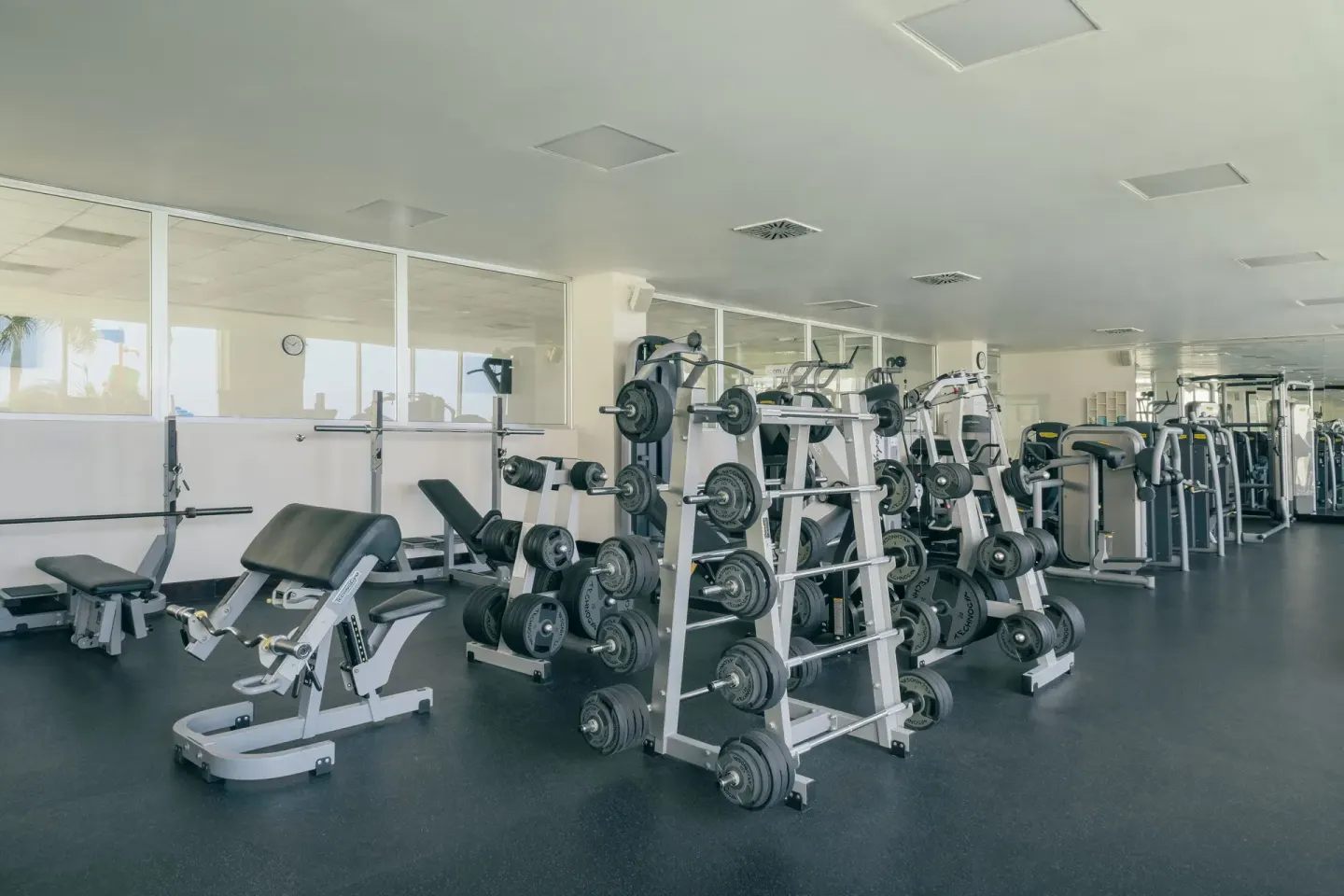 Fitness center with weight machines and benches at Iberostar Selection Rose Hall Suites.